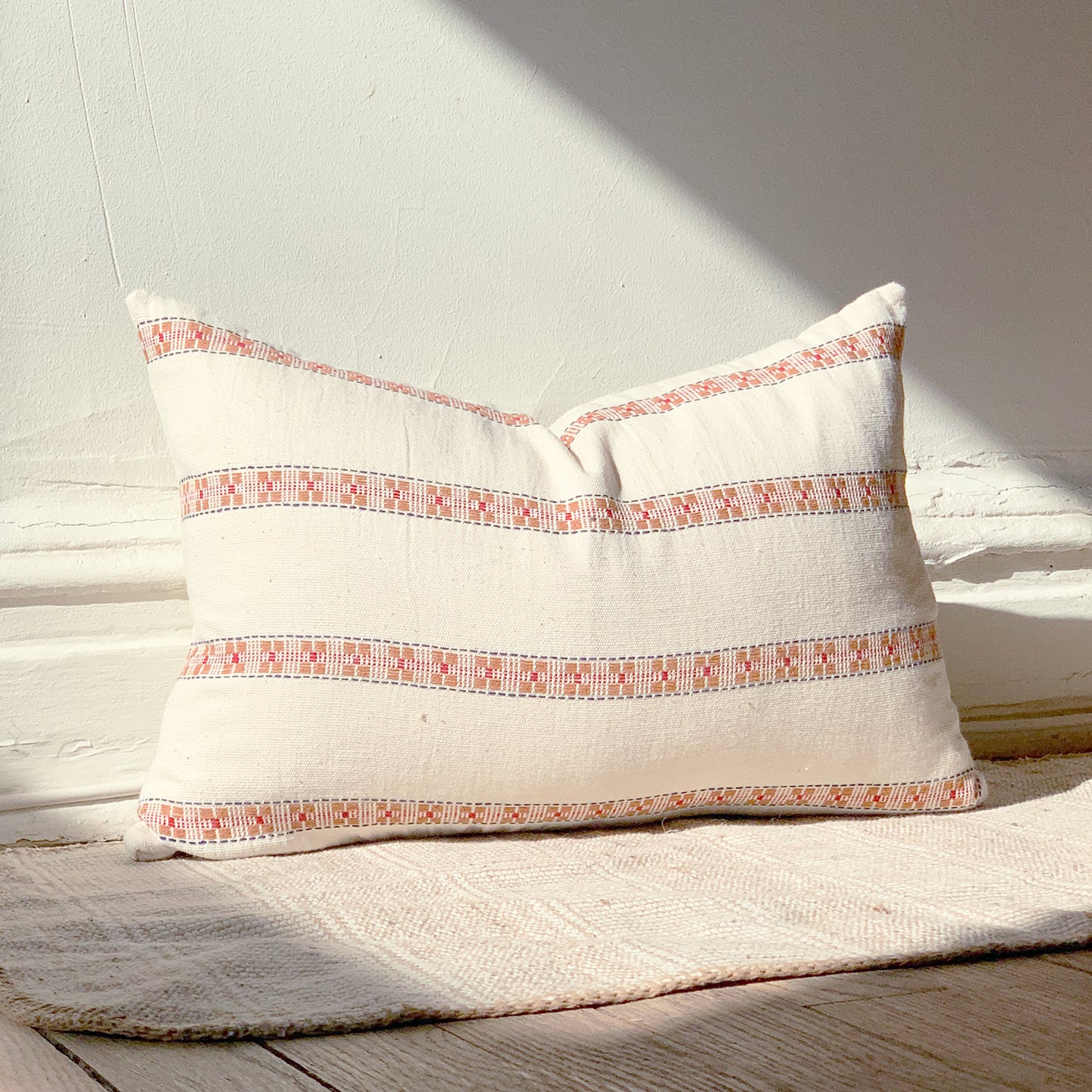 Handmade natural cotton throw pillow with patterned stripes and orange color accents